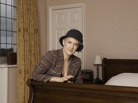 Woman wearing lingerie with a tweed jacket and hat