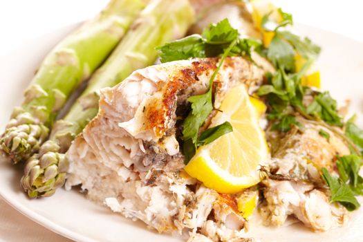 Fish dish with asparagus, greens and lemon.