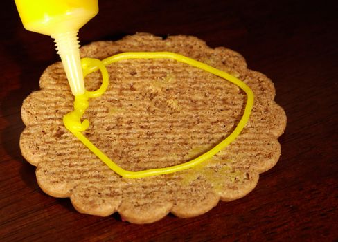 Drawing on ginger cookies. Macro shot.