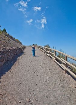 Lady walking for exercises during a sunny day on a mountain path