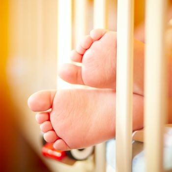 Baby feet in the playpen. Close up.