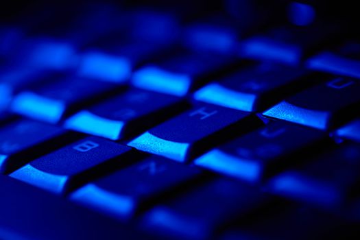 Computer keyboard in blue light. Small depth of field.