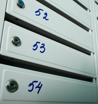 Gray blue metallic mailboxes with flat numbers.