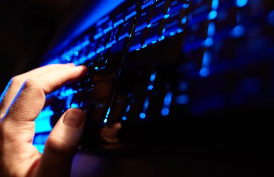 Beautiful business concepts. Man's hand typing on a blue keyboard. Horizontal shot.