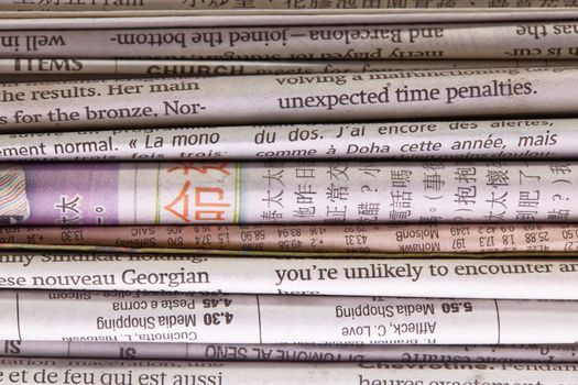 Detail of a pile of international newspapers. Great abstract newspaper background.