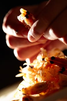 Shrimp in hands. Macro shot with beautiful backlight. Vertical shot.
