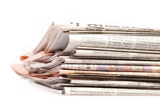 International newspapers on white background. Beautiful shallow dof.