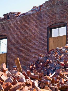 A demolition site with a pile of demolished brick wall and concrete debris