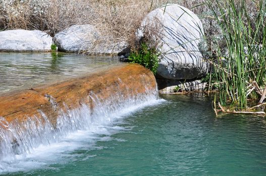 Water spills over a small ledge at a pond in Whitewater Canyon near Palm Springs, California.