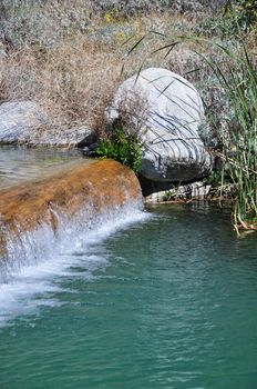 Water spills over a small ledge at a pond in Whitewater Canyon near Palm Springs, California.