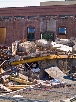 A demolition site with a pile of demolished brick wall and concrete debris
