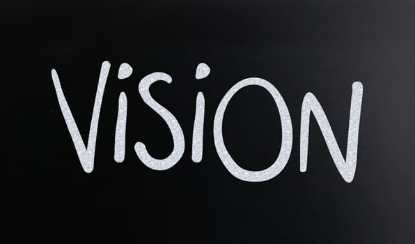 The word "Vision" handwritten with white chalk on a blackboard