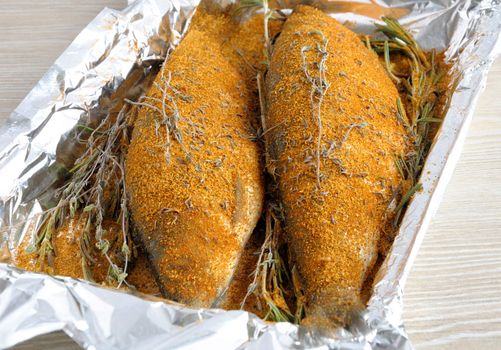 Fresh herring in spices and herbs in foil