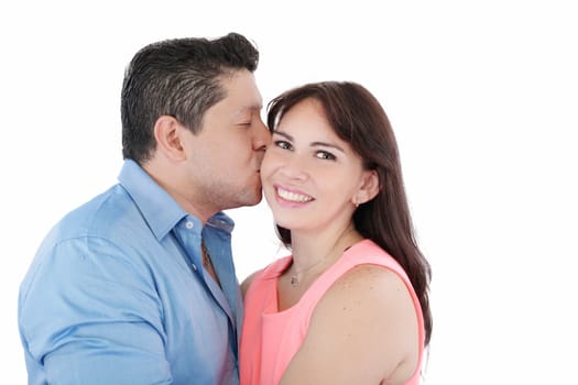 Close-up portrait of woman being affectionately kissed by her husband