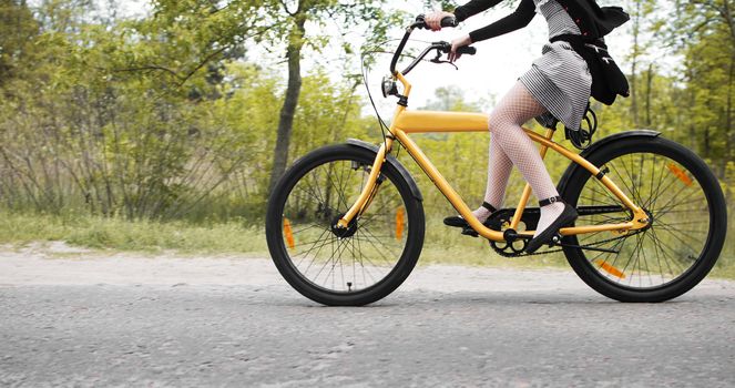 young girl in dress and stockings cycling on custom bike