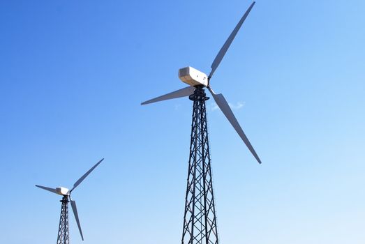 wind energy, modern white wind turbines or wind mills producing energy to power a city