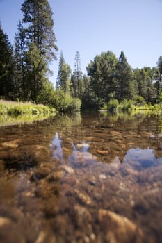 Flowing river in the spring with a blue sky anclear water