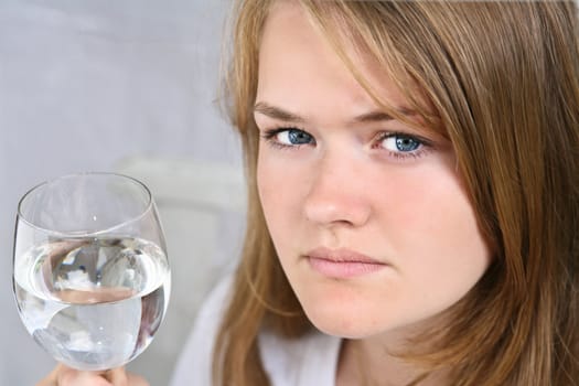Girl with a glass of water looking at the camera