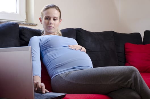 pregnant woman working from home thinking about her work