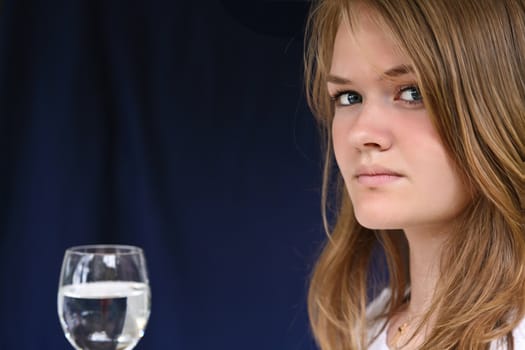 Girl with a glass of water looking at the camera