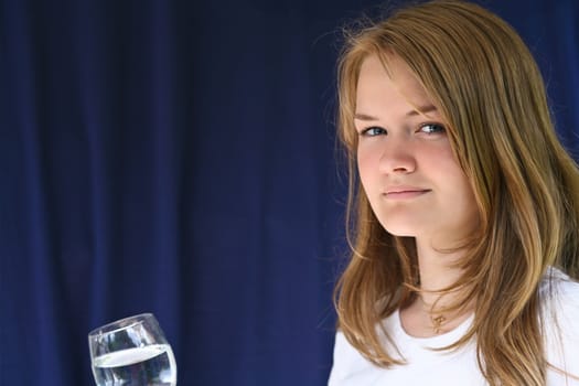 Girl with a glass of water looking at the camera