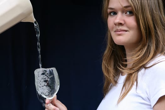 Girl with a glass of water looking at the camera