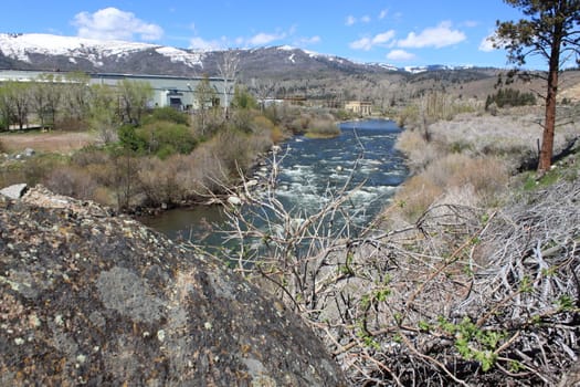 Flowing river in the spring with a blue sky anclear water