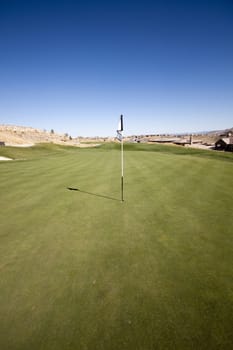 Golf course with green grass and clear blue skies.