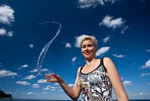 Cute blond girl playing with water in the summer in Denmark