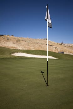 Golf course with green grass and clear blue skies.