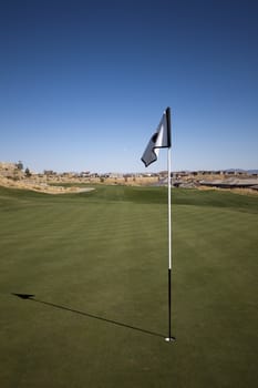 Golf course with green grass and clear blue skies.