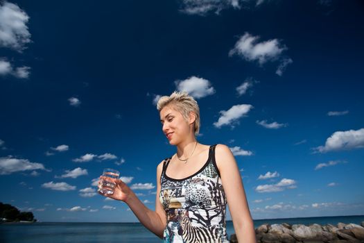 Cute blond girl playing with water in the summer in Denmark