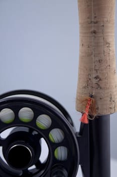 macro of a fly fishing reel and rod with a fly.