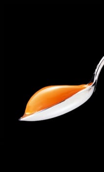 yolk in the spoon on a black background
