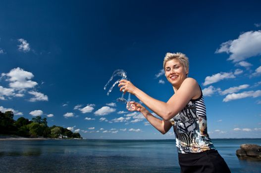 Cute blond girl playing with water in the summer in Denmark