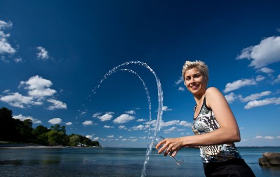 Cute blond girl playing with water in the summer in Denmark