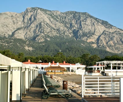 Sky, ocean, mountain, beach, and buildings close up