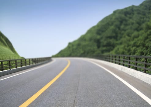 Road and blue sky near the green forest