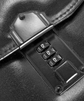 combination safe on black leather bag close up