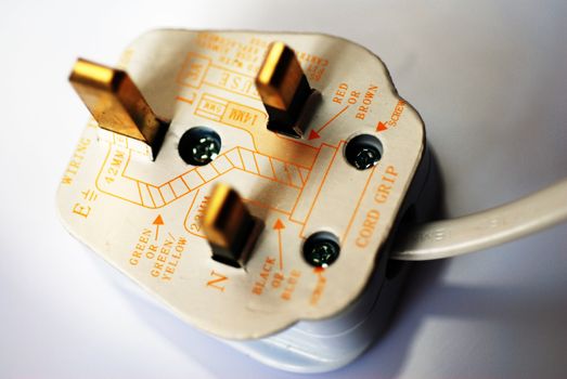 A UK electrical plug, with the camera's focus on the wiring instructions