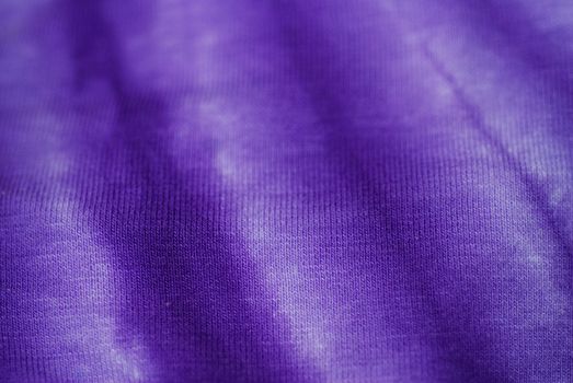 Fabric tie-dyed in purple, an abstract ideal as a background.