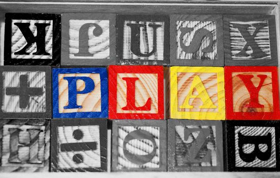 The word PLAY spelled out in educational wooden block toys