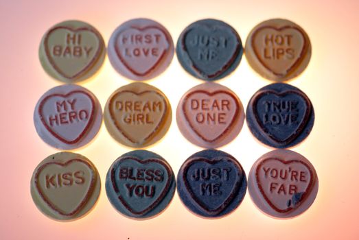 Twelve sweets with loving messages arranged in rows.