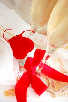 Two glasses of champagne and fabric heart in front