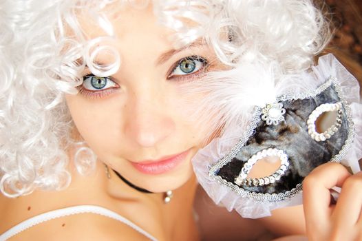 Beautiful girl in white twig holding mask