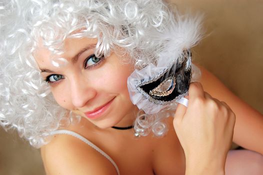 Beautiful girl in white twig holding mask