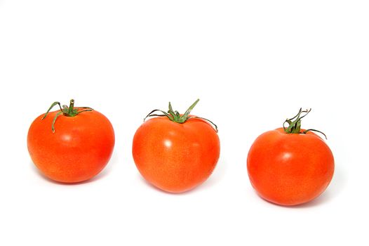 Three ripe red tomatos with green ends isolated on white