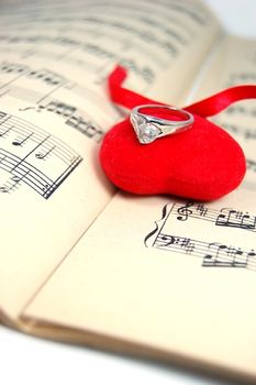 fabric neart with ring on sheet of music