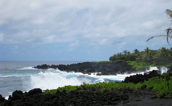 Waves crashing onto a black sand beach 