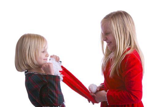 Girls fighting over a santa hat in Christmas dresses